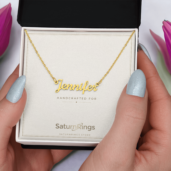 Gold Jennifer cursive name necklace and gift box held in two hands